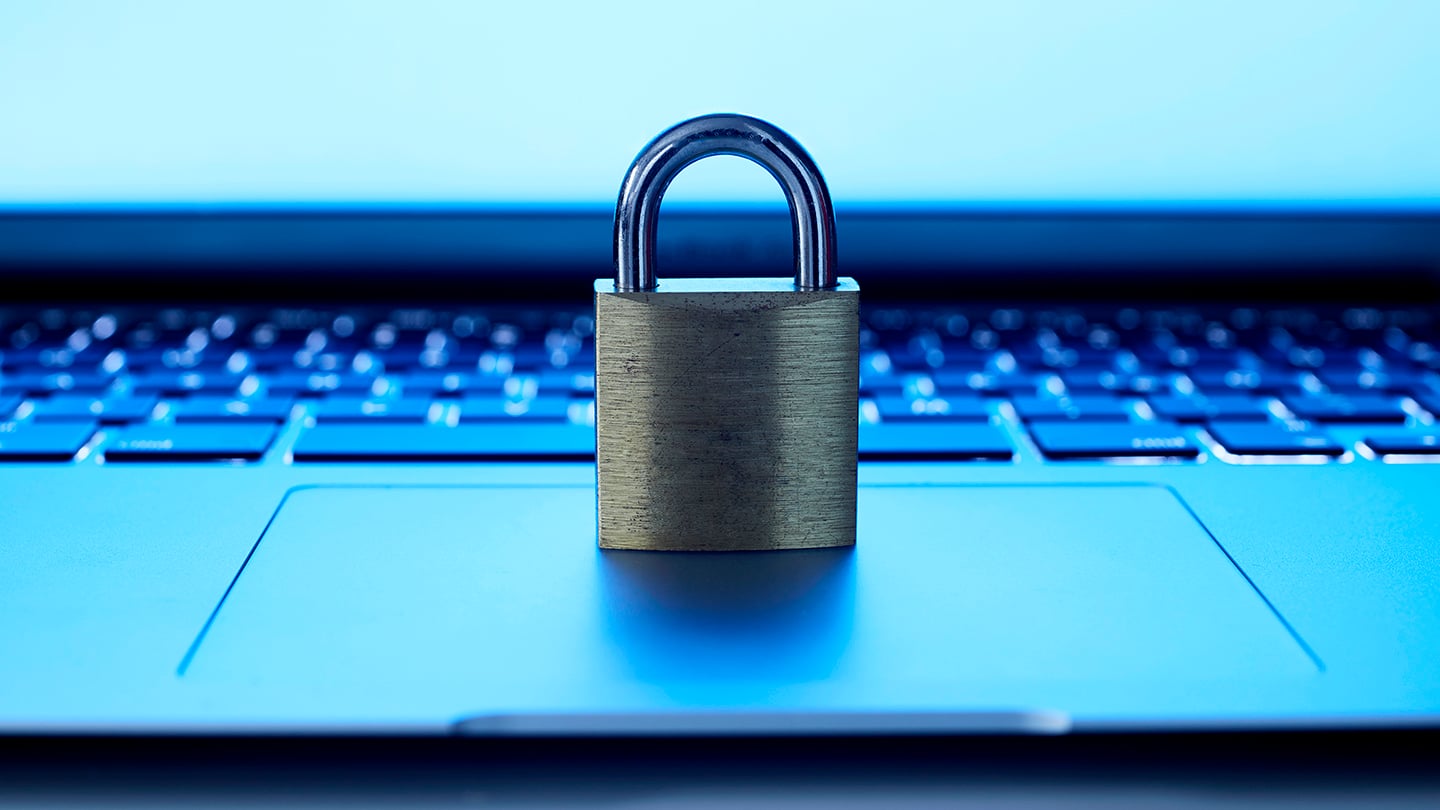Close up view of a gold padlock on a laptop track pad