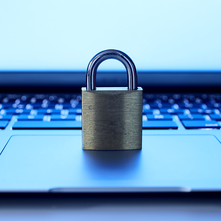 Close up view of a gold padlock on a laptop track pad