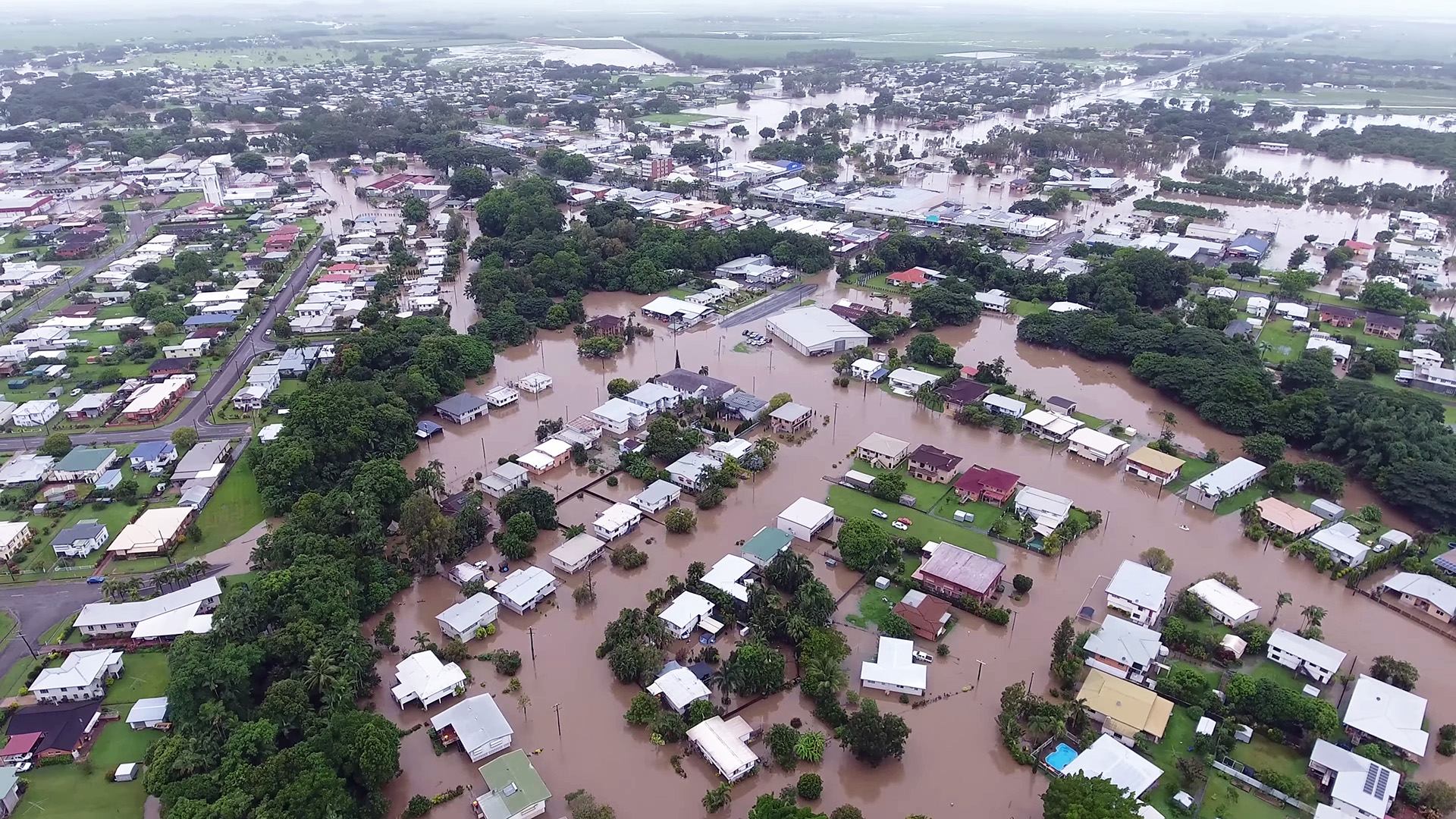 aerial view of flooded neighborhood with brown water